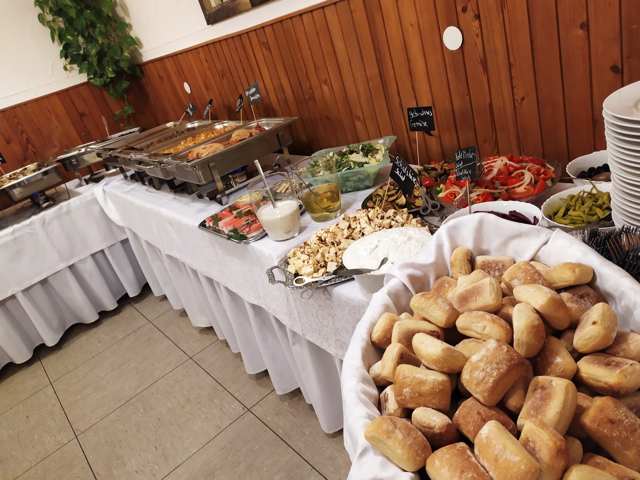 Buffettafel mit weißer Tischdecke und einem großen Brötchenkorb