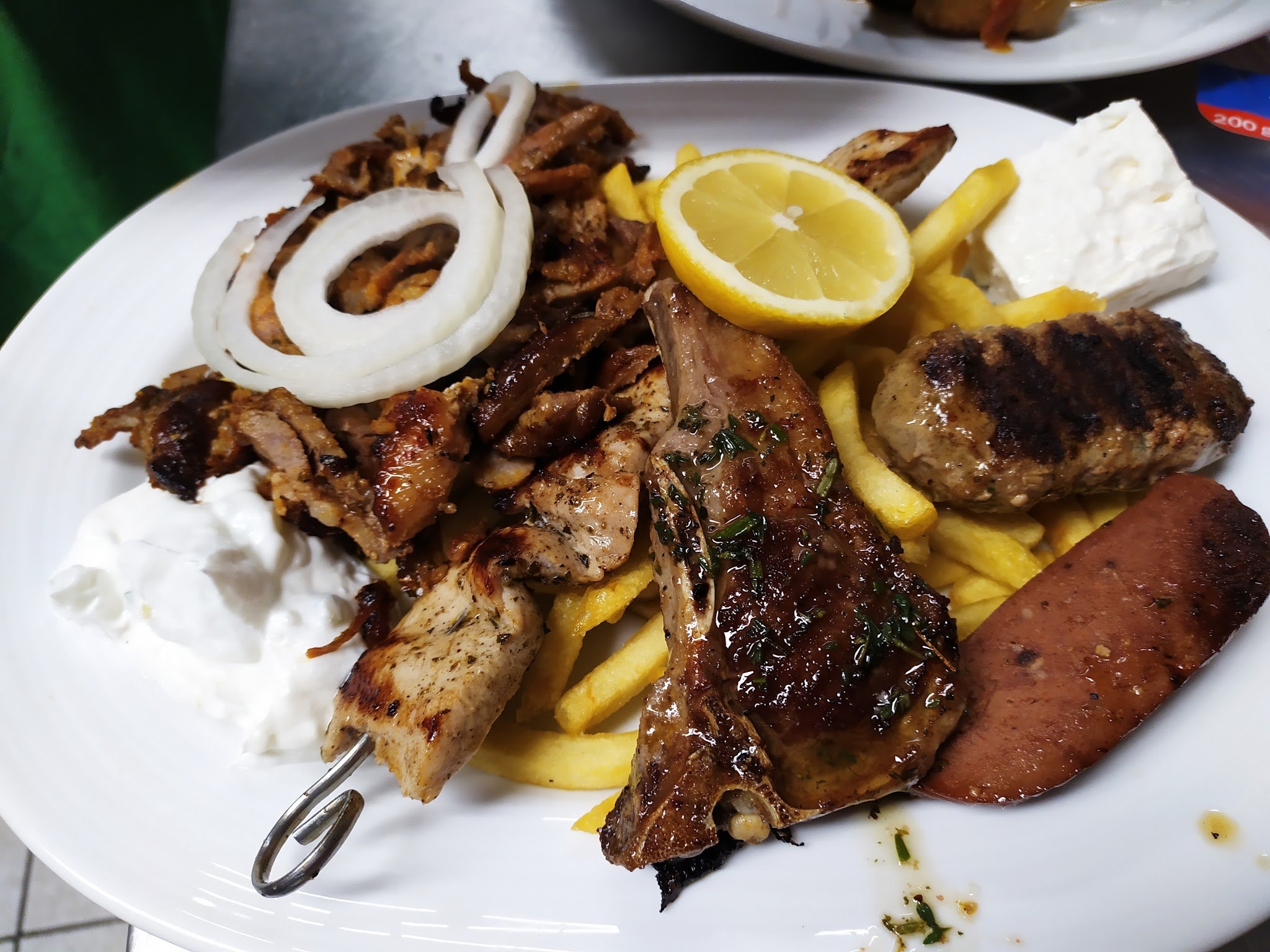 Gemischter Grillteller mit Gyros, Spieß, Bifteki, Pommes frites, Zaziki und Zitrone