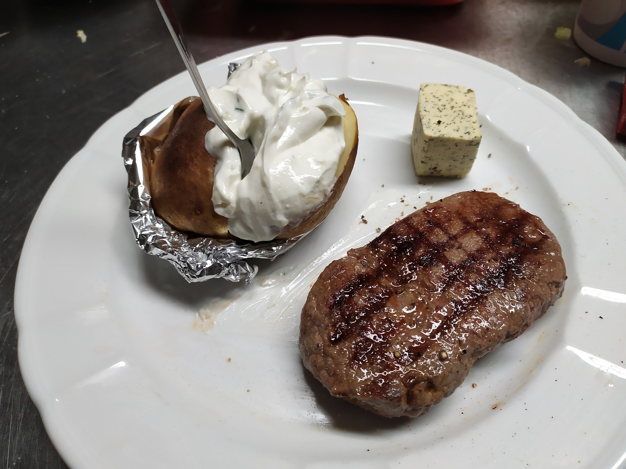 Gegrilltes Steak mit Folienkartoffel, Sauerrahm und Kräuterbutter